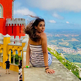 Elizabeth De La Rosa sitting on a wall overlooking a landscape